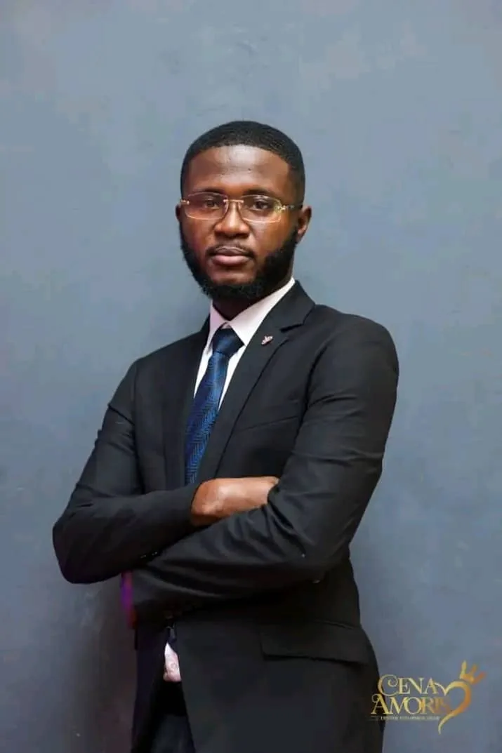 Portrait of Ernest Asiamah, Operations Officer, standing with arms folded in a dark suit and tie